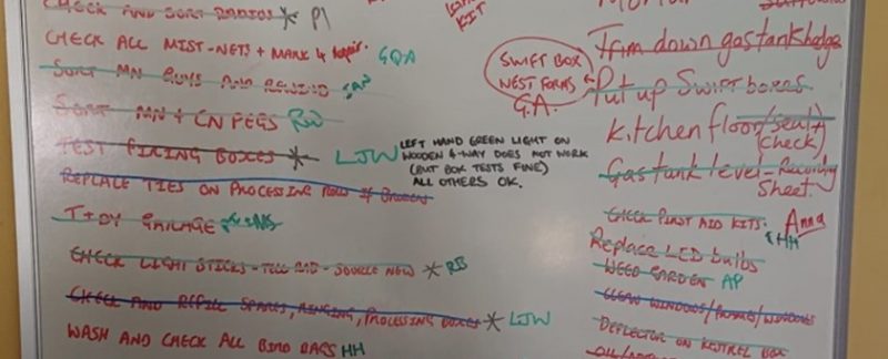 A white board with a lit of jobs that needed doing over the weekend written in red, green and blue ink. Many of the jobs have been crossed off as work progresses.